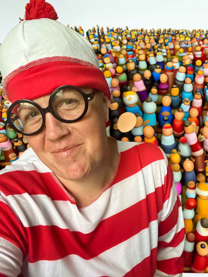 A person wearing red and white stripped hat and shirt with cartoon people in the background.